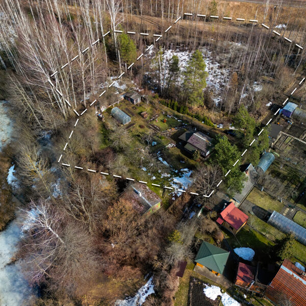 Аэросъемка для визуализации границ земечльного участка на берегу озера с жилой застройкой